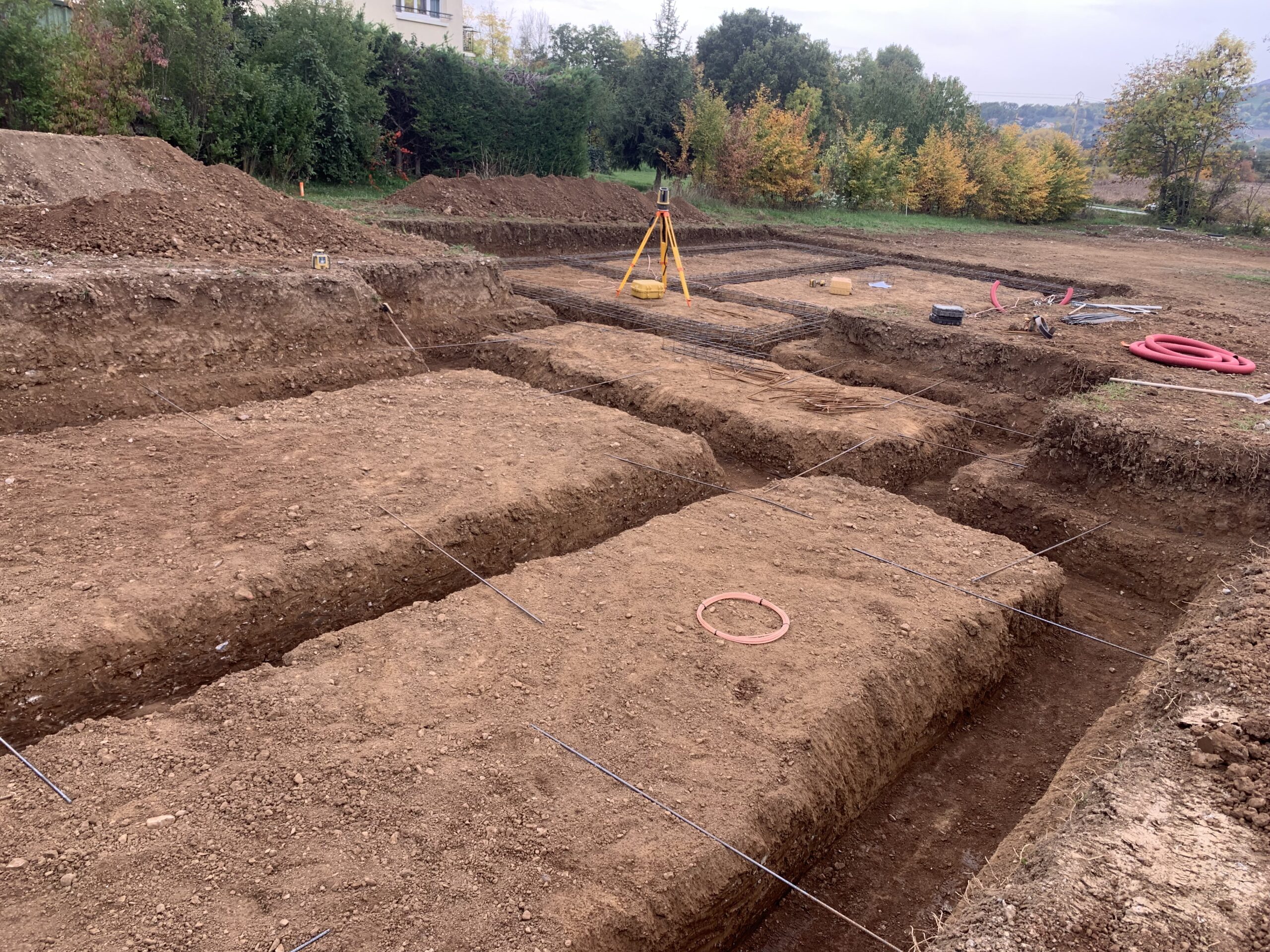 Terrassement en cours à Gap – pelle hydraulique DB Construction réalisant des fouilles de fondation sur un chantier de maison individuelle dans les Hautes-Alpes (05)